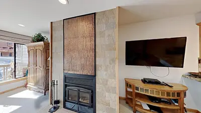 a living room with a fireplace and a tv at One Bedroom Condo Close To Canyon Lodge! in Mammoth Lakes