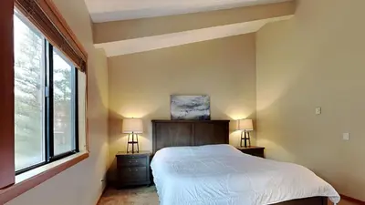 a bedroom with a bed and two lamps and a window at Beautifully Remodeled 4 Bedroom Home in Mammoth Lakes