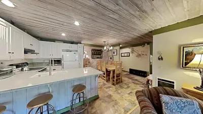 a kitchen with a counter top and a living room at Beautiful Remodeled One Bedroom Condo! in Mammoth Lakes
