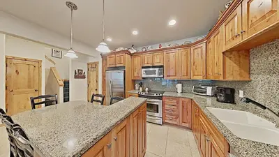 a kitchen with wooden cabinets and a counter top at Cozy One Bedroom Condo with Loft! in Mammoth Lakes