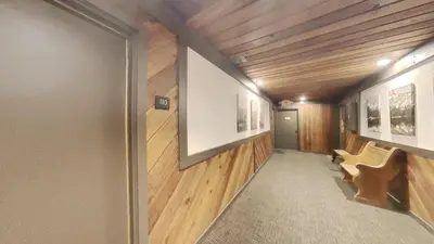 a hallway with wood paneling and a door with a bench at Spacious One Bedroom Condo with Full Kitchen! in Mammoth Lakes