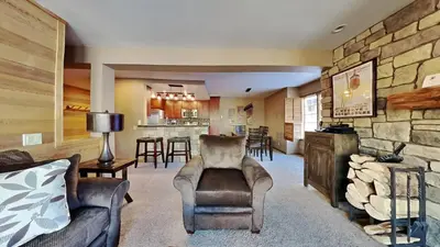 a living room with a couch and a stone wall at Remodeled 2 Bedroom Condo withFull Kitchen! in Mammoth Lakes