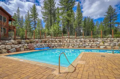 a swimming pool with a stone wall around it at Comfortable and Convenient Truckee Condo in Truckee