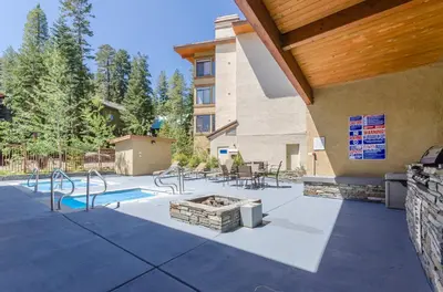a patio with a fire pit and a building at Silver Bear #22 condo in Mammoth Lakes