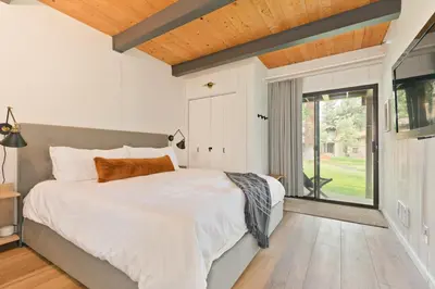 a bedroom with a large bed and a large window at Villa de los Pinos 42 in Mammoth Lakes