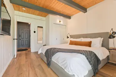 a bedroom with a large bed and a wooden ceiling at Villa de los Pinos 42 in Mammoth Lakes