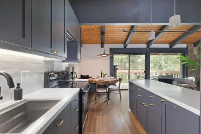 a kitchen with blue cabinets and a dining table at Villa de los Pinos 42 in Mammoth Lakes
