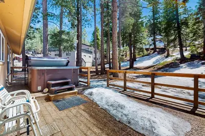 a hot tub on a deck with a snow covered yard at Makoto in Stateline