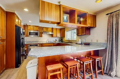 a kitchen with wooden cabinets and a counter with stools at Makoto in Stateline