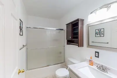 a bathroom with a shower and a toilet and a sink at Holiday Chalet in Groveland