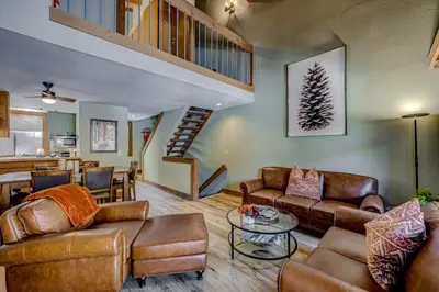 a living room with leather furniture and a staircase at Enjoyable Northstar Condo in Kingswood Estates