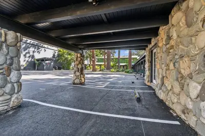 an empty parking lot with a stone wall at South Lake Chalet by Heavenly in South Lake Tahoe