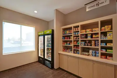 a store aisle with a refrigerator and shelves of food at Home2 Suites By Hilton Turlock, Ca in Turlock