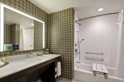 a bathroom with a sink and a tub and a mirror at Home2 Suites By Hilton Turlock, Ca in Turlock