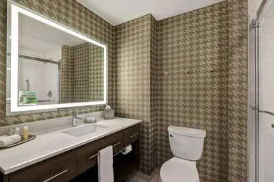 a bathroom with a toilet and a sink and a mirror at Home2 Suites By Hilton Turlock, Ca in Turlock