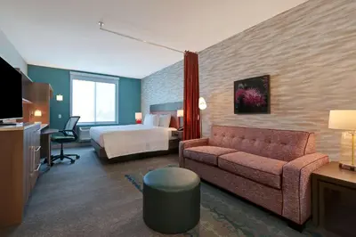a hotel room with a bed and a couch at Home2 Suites By Hilton Turlock, Ca in Turlock