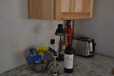 a bottle of wine sitting on a counter next to a toaster at In The Oaks in Three Rivers