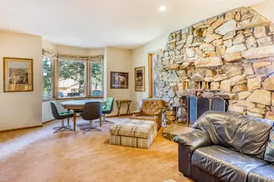 a living room with a large stone fireplace at Homewood Bliss in Homewood