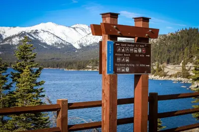 a sign on a fence next to a lake at Linda's Lakehouse in Incline Village