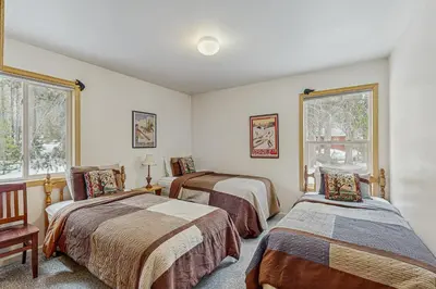 a bedroom with two beds and two windows at Poma Lane in Soda Springs