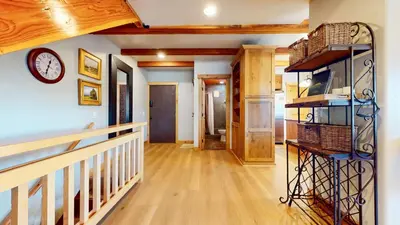 a hallway with a clock and baskets on a wall at Val DIsere #10 condo in Mammoth Lakes