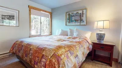 a bedroom with a bed and a table with a lamp at Val DIsere #10 condo in Mammoth Lakes