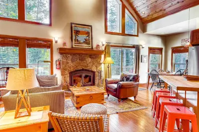 a living room with a fireplace and a table at Sugar House in Soda Springs