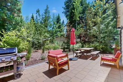 a patio with chairs and an umbrella and a grill at Bearing Drive Escape in Tahoe City