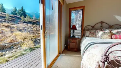 a bedroom with a bed and a sliding glass door at Snowcreek V #774 condo in Mammoth Lakes