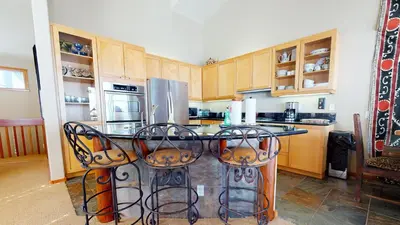 a kitchen with a table with chairs and a refrigerator at Snowcreek V #774 condo in Mammoth Lakes