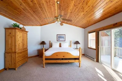 a bedroom with a bed and a wooden ceiling at Skidder Trail Family Lodge home in Truckee