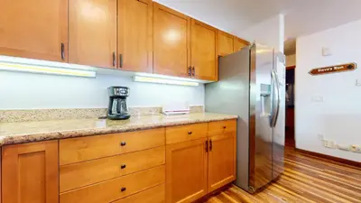 a kitchen with wooden cabinets and a refrigerator at Eagle Run #103 condo in Mammoth Lakes