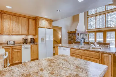 a kitchen with wooden cabinets and a white refrigerator at Four Seasons Lakeside in Soda Springs