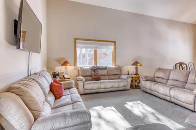 a living room with two couches and a flat screen tv at Four Seasons Lakeside in Soda Springs