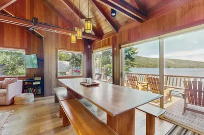 a dining room with a table and views of the water at Beaver Cove Lodge in Truckee