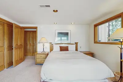 a bedroom with a large white bed and a window at Beaver Cove Lodge in Truckee