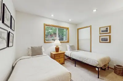 two beds in a room with white walls at Beaver Cove Lodge in Truckee