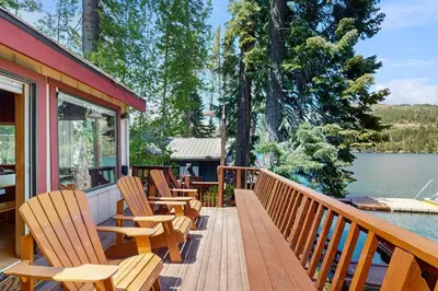 a deck with chairs on a house next to a lake at Beaver Cove Lodge in Truckee