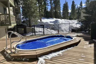 a hot tub sitting on a deck in the snow at Crestview 36 in Mammoth Lakes