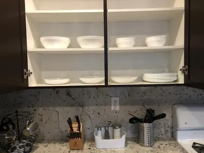 a kitchen cabinet filled with white bowls and utensils at Modern Luxury Living, relax and enjoy your stay! in Rancho Cordova