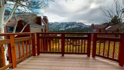 a wooden deck with a view of the mountains at Meadow Ridge #28 condo in Mammoth Lakes