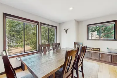 a dining room with a table and chairs and windows at Meadowview in Truckee