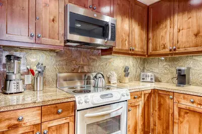 a kitchen with wooden cabinets and a stove and microwave at Northstar Village #410 in Kingswood Estates
