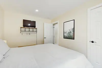 a bedroom with a white bed and a flat screen tv at Heavenly Hideaway in Stateline
