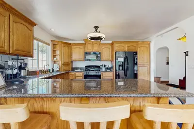 a kitchen with wooden cabinets and a island with bar stools at Life on Mt Olympia in South Lake Tahoe