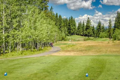 a golf course with a car driving down a road at Snowdream in Ponderosa Fairway Estates