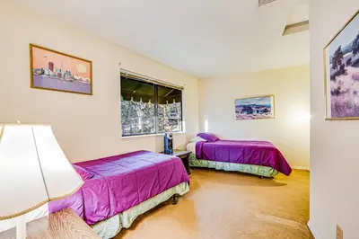 two beds in a room with purple sheets at Luring Lakefront Landing in Groveland