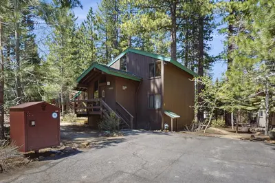 a house in the woods with a driveway at Indian Hill Hush in Truckee