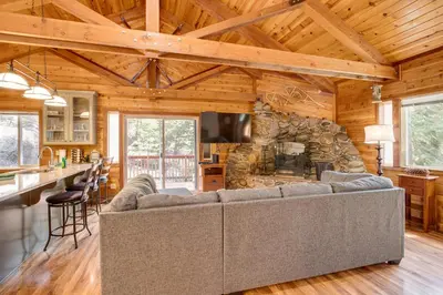 a living room with a couch and a stone fireplace at 1 Mi to Heavenly Resort Cozy Home with Deck! in Stateline