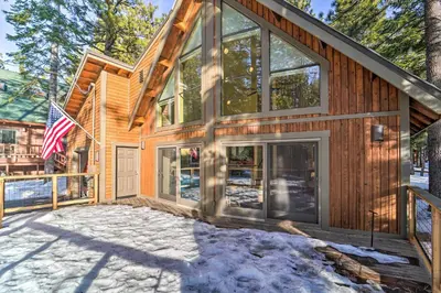 a house with glass doors and a flag at 4 Mi to Dtwn Truckee Tahoe Donner Home with Hot Tub in Truckee